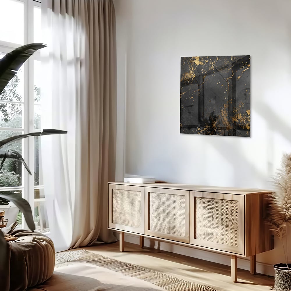 Modern glazen schilderij met abstracte gouden spatten op een zwarte achtergrond.