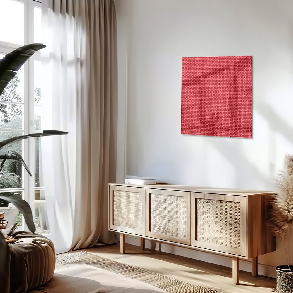 Modern glazen schilderij in helder rood aan de muur boven een licht houten kast.