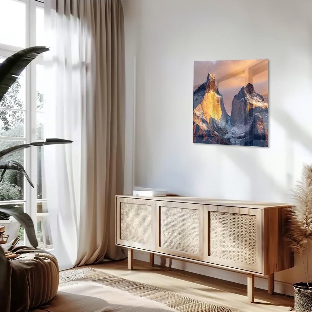 Een glazen schilderij van majestueuze bergen met gouden ochtendlicht