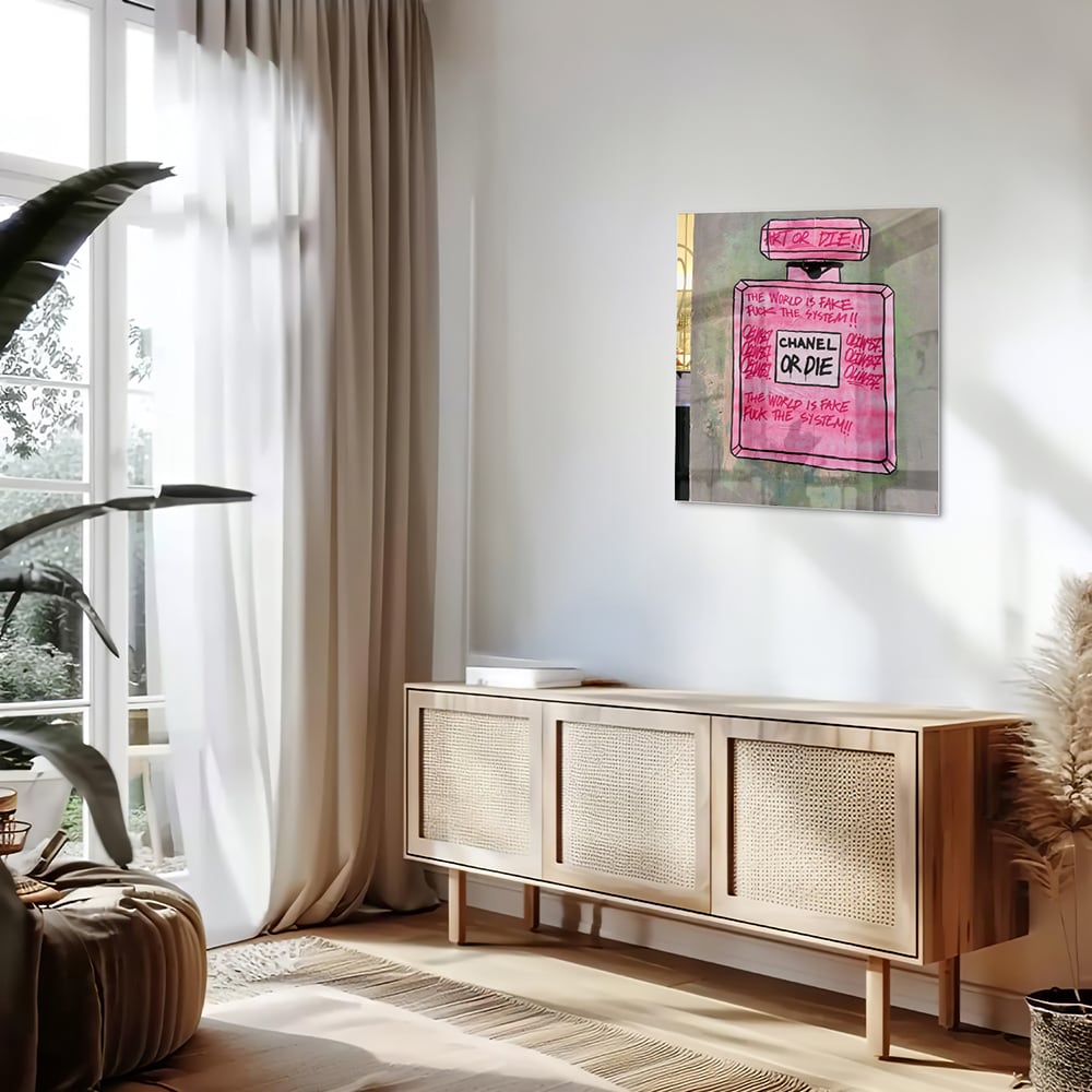 Glazen schilderij met de tekst 'Chanel or Die' in felle kleuren aan de muur.