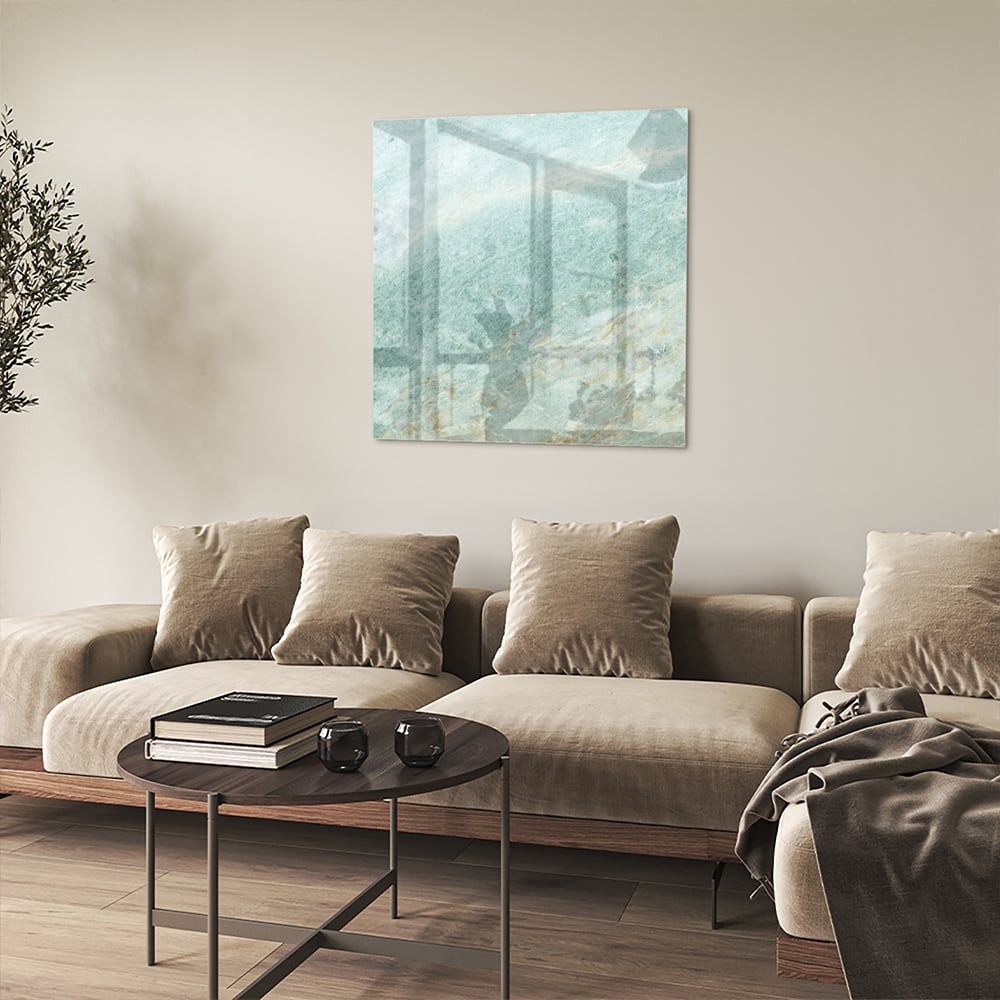 Abstract glazen schilderij in groentinten aan de muur in een moderne woonkamer.