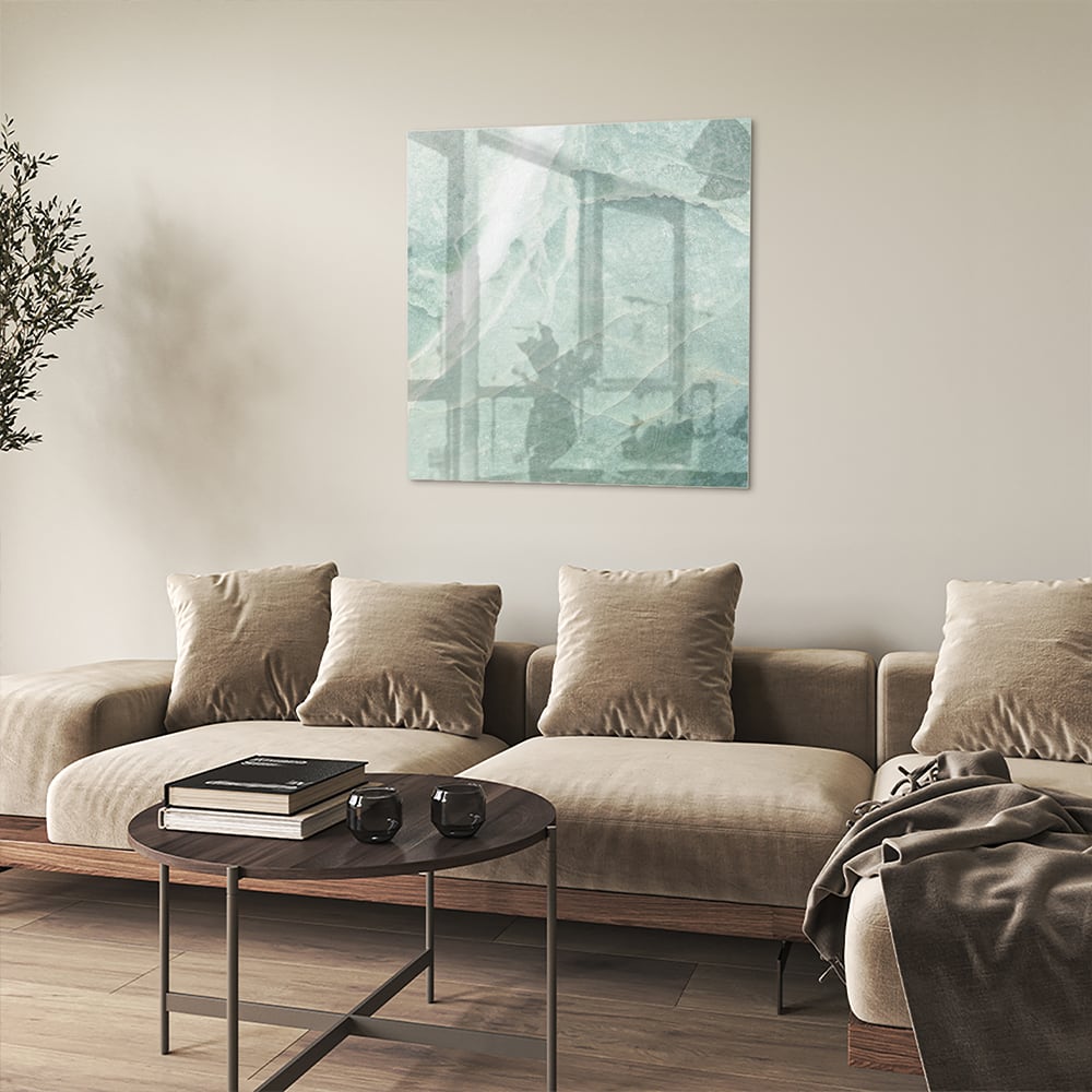 Abstract groen glazen schilderij aan de muur boven een houten meubel.