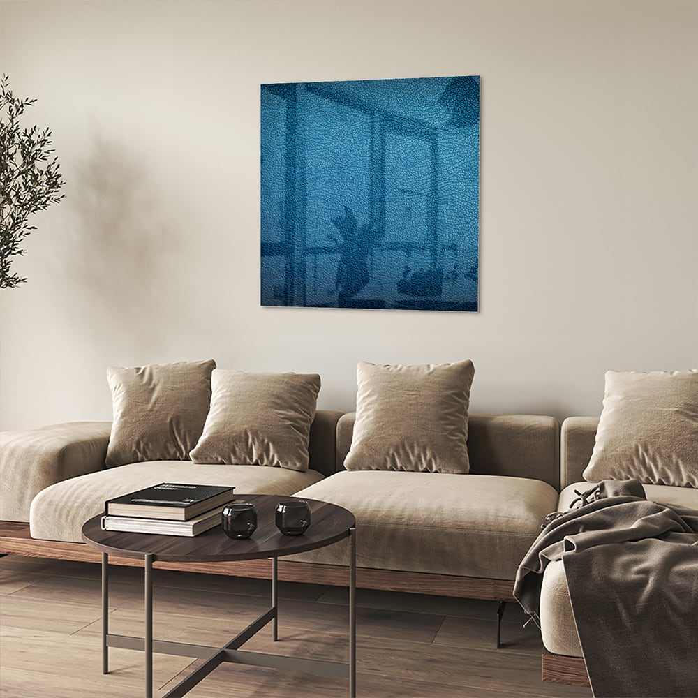 Blauw glazen schilderij met reflecties aan de muur in een moderne woonkamer.