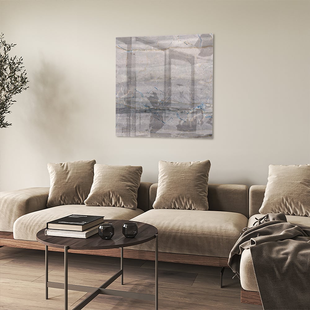 Glazen schilderij in aardetinten hangt aan de muur in een moderne woonkamer.