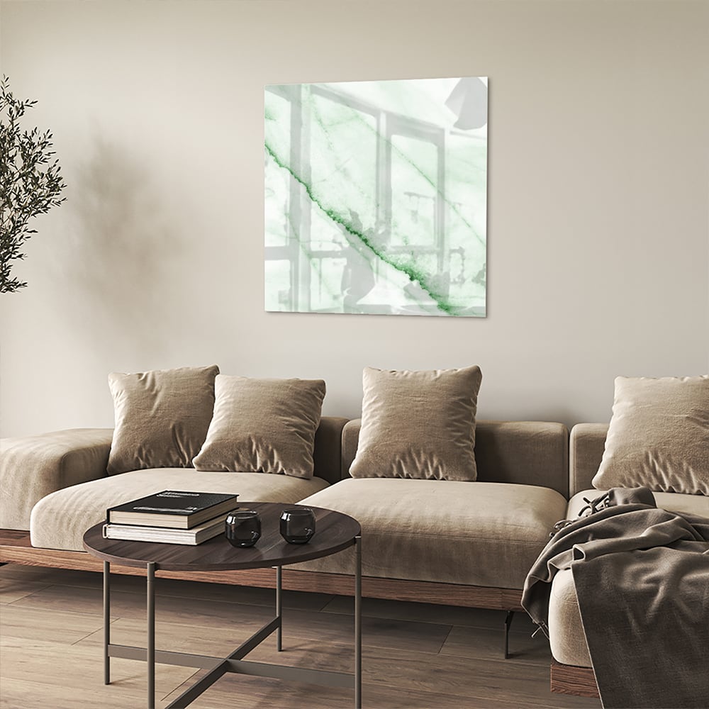 Glazen schilderij met een groene marmerlook aan de muur in een moderne woonkamer.