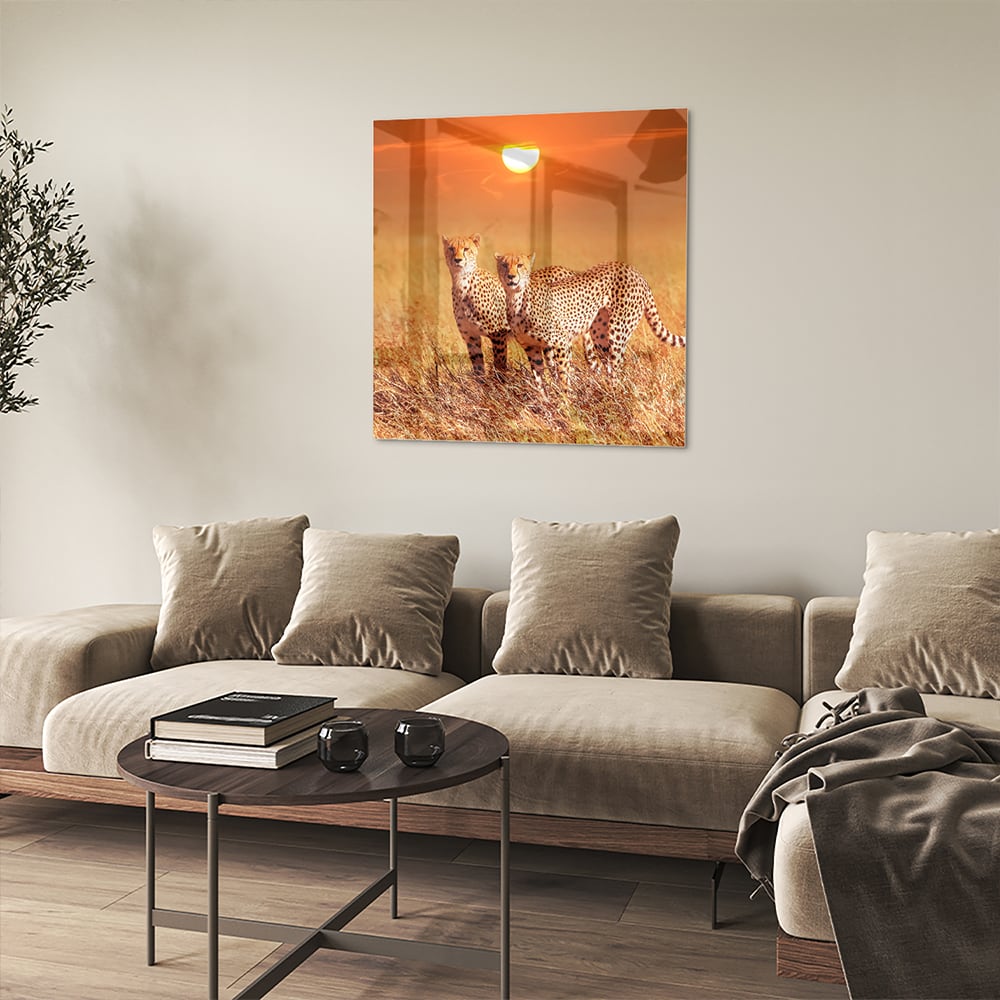 Glazen schilderij van twee cheeta's in een gouden savanne bij zonsondergang.