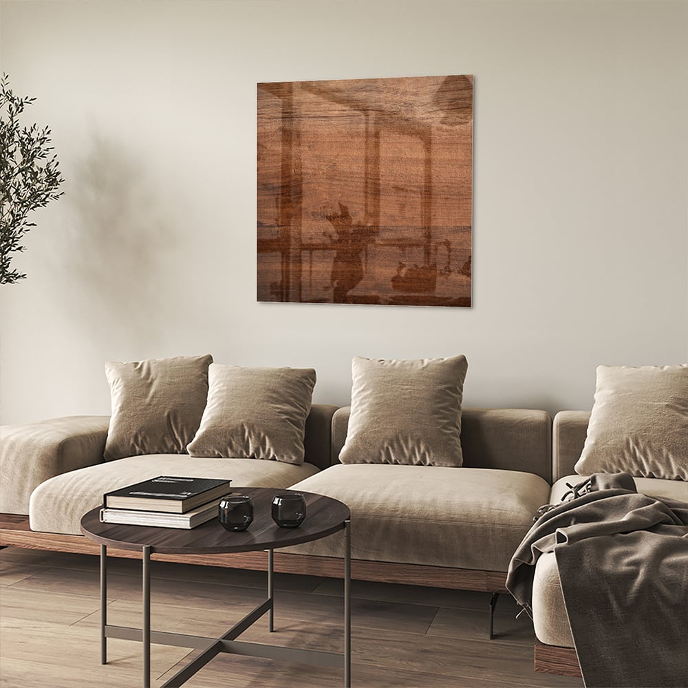 Glazen schilderij in warme houttint hangt boven een moderne kast in een woonkamer.