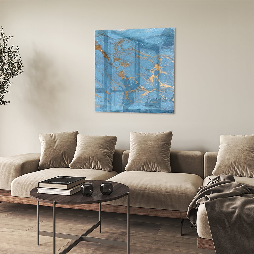Glazen schilderij met blauw en gouden patronen aan de muur boven een houten kast.