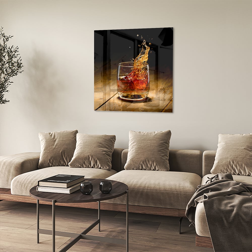 Glazen schilderij met een glas en spetterende drank op een houten tafel.