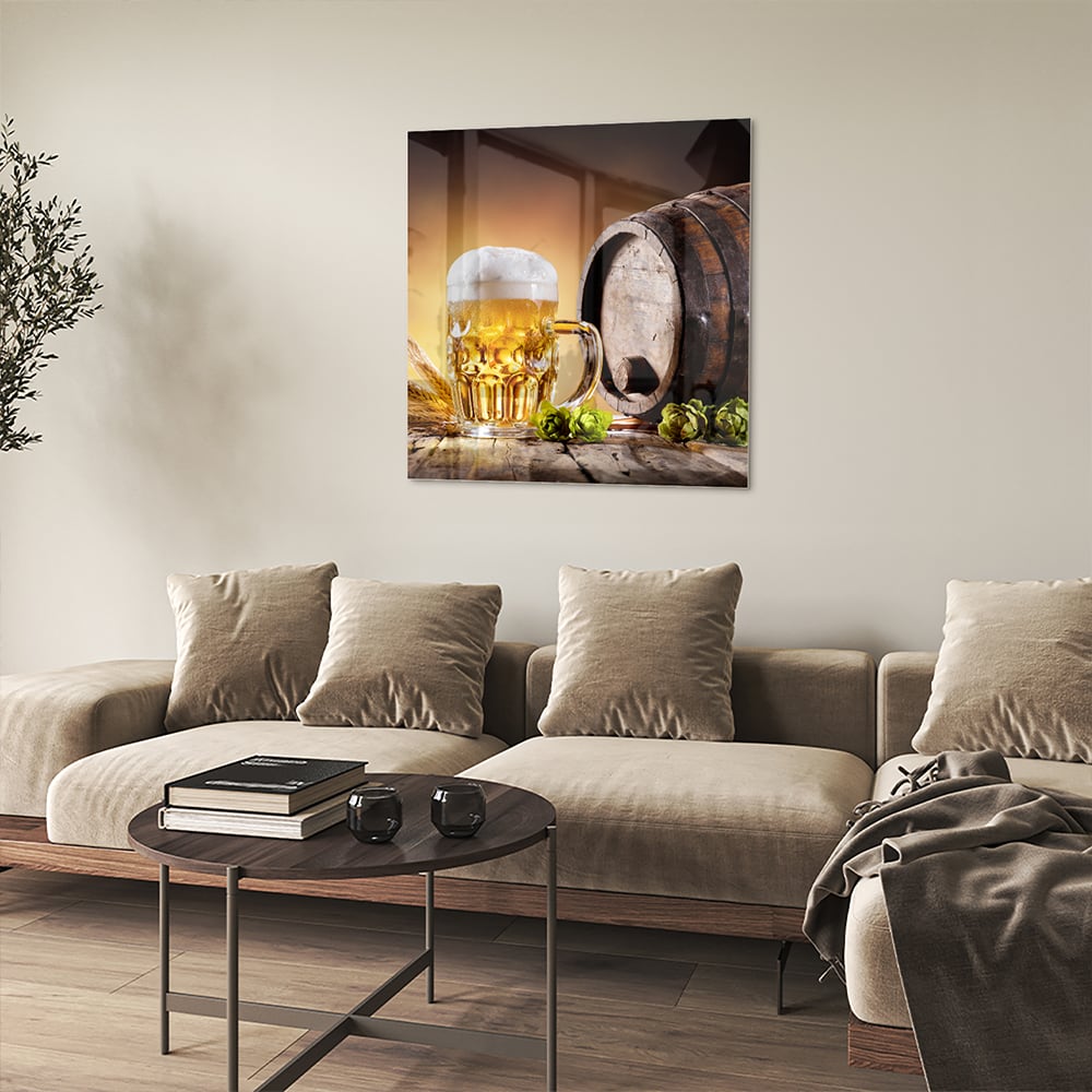 Glazen schilderij van een koud biertje op een houten tafel met groen in de achtergrond.