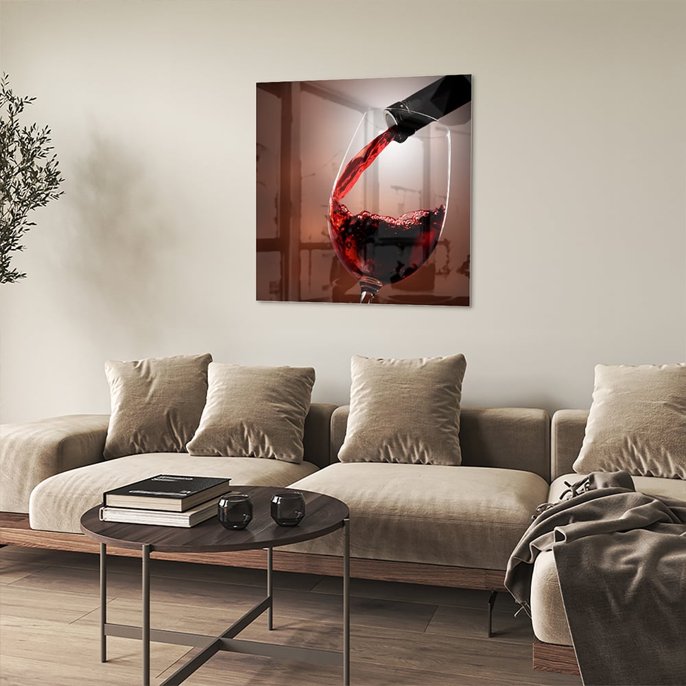 Glazen schilderij van een rode wijn die in een glas wordt ingeschonken, zichtbaar in een moderne woonkamer.