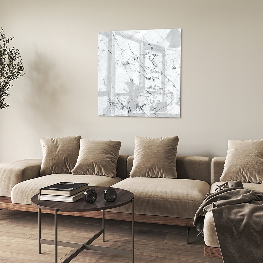 Glazen schilderij met marmerlook aan de muur in een moderne woonkamer.