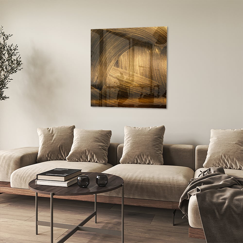 Glazen schilderij met gouden patronen aan de muur boven een houten meubel.