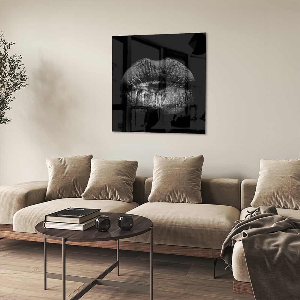 Zwart glazen schilderij met een artistieke lippenprint aan de muur.
