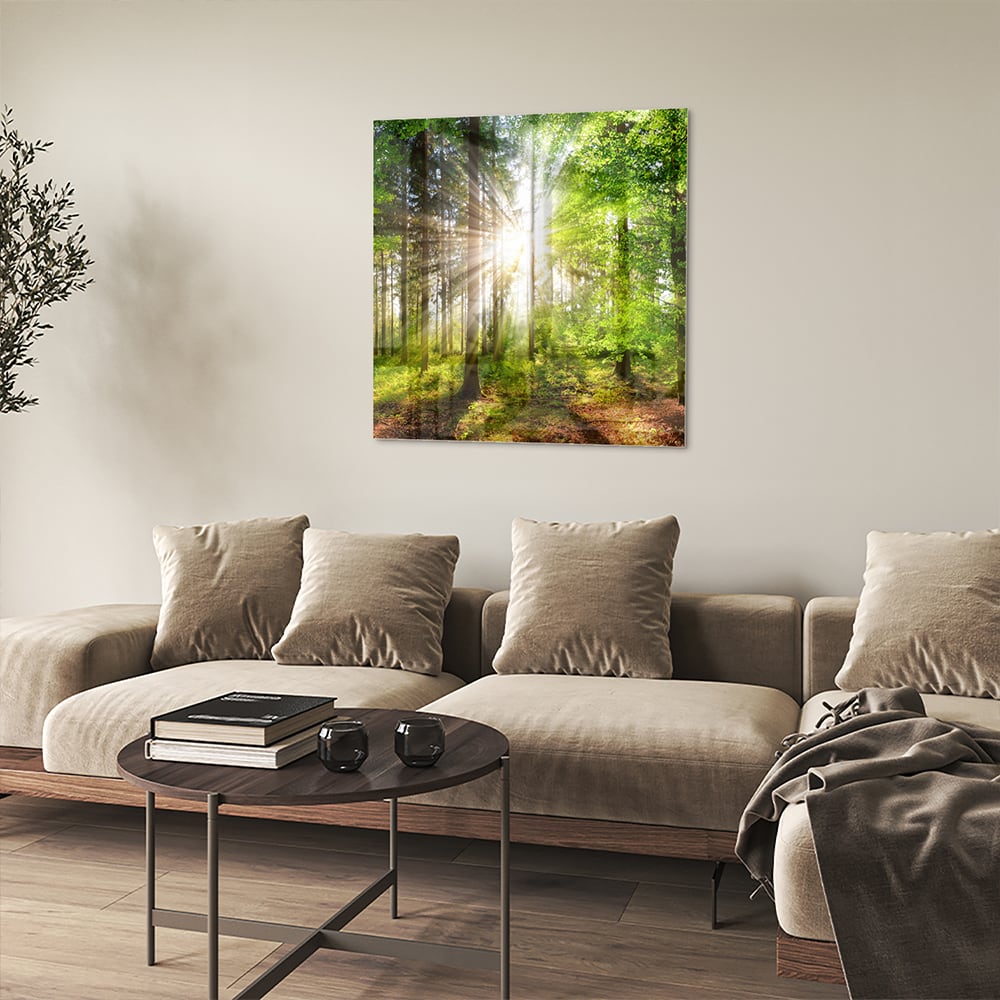 Glazen schilderij van een bos met zonnestralen op een muur.
