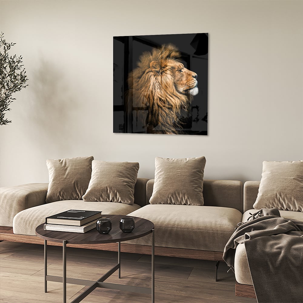 Glazen schilderij van een leeuw met rijke, gouden manen tegen een zwarte achtergrond.