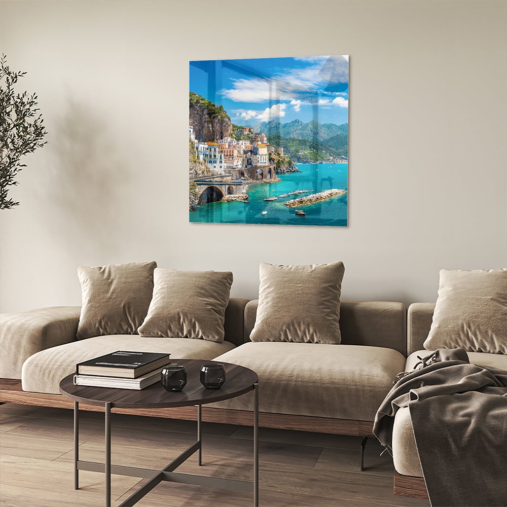 Glazen schilderij van een kustlandschap met blauwe zee en groene bergen.