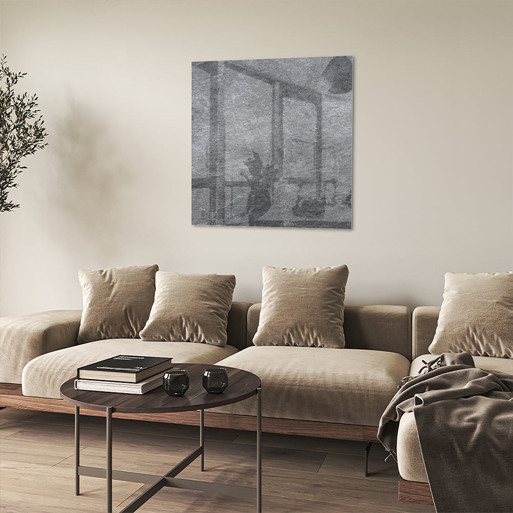 Modern glazen schilderij in grijs hangt aan de muur in een rustig interieur.