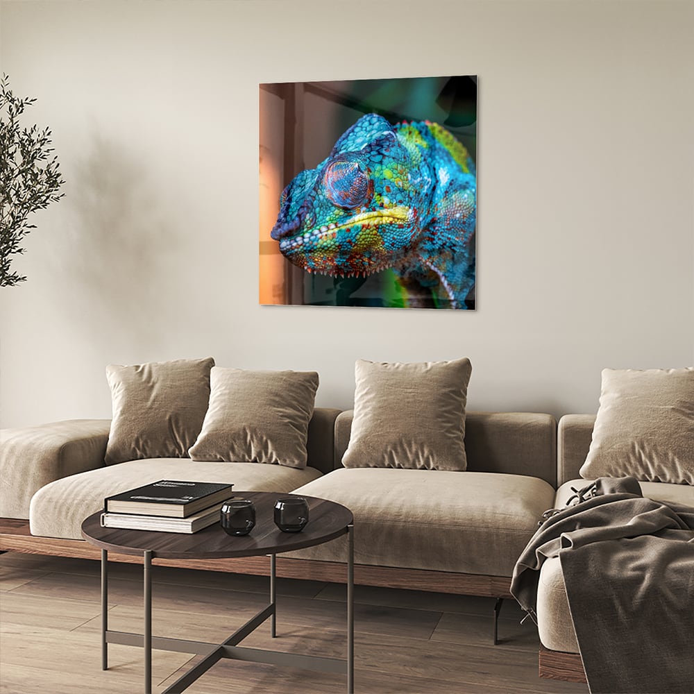 Glazen schilderij van een kleurrijk chameleon hangt aan de muur