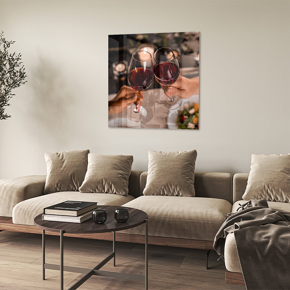 Een glazen schilderij van twee mensen die proosten met rode wijn in een stijlvolle setting.