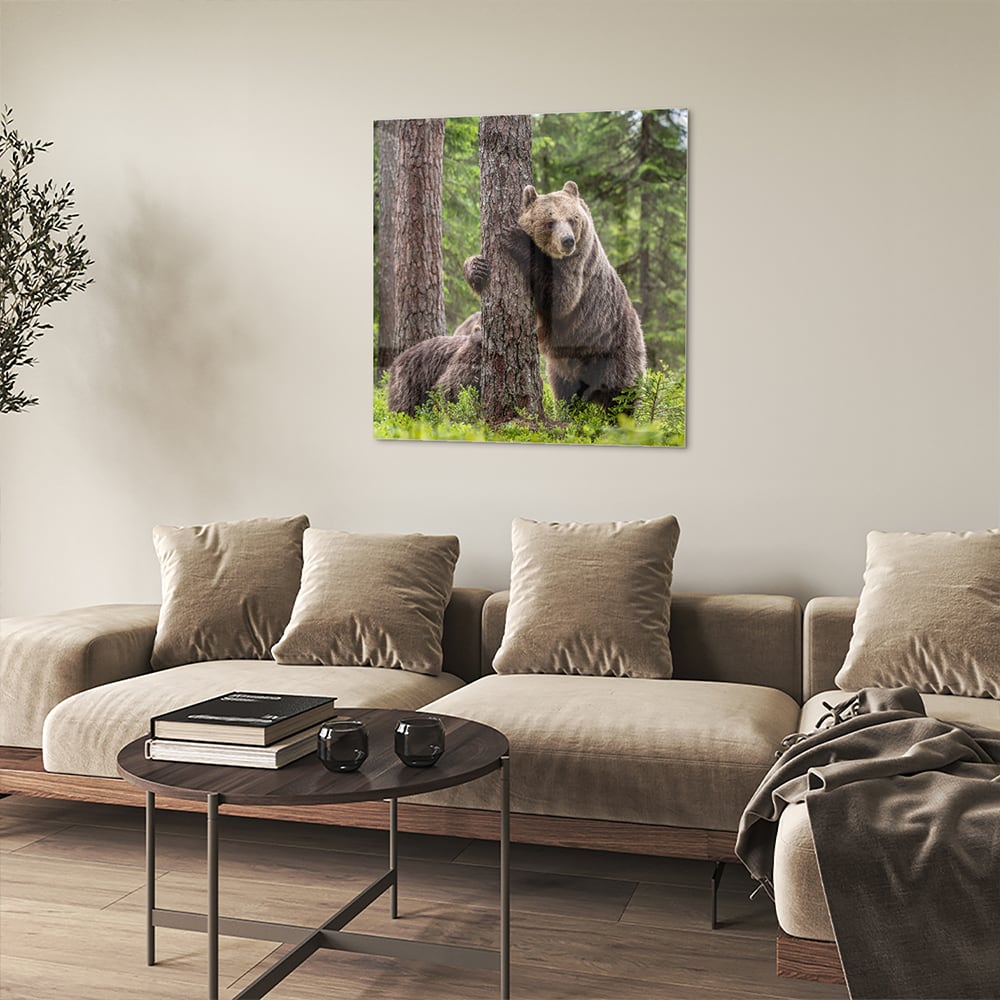 Glazen schilderij van een grizzly beer leunend tegen een boom in de natuur.