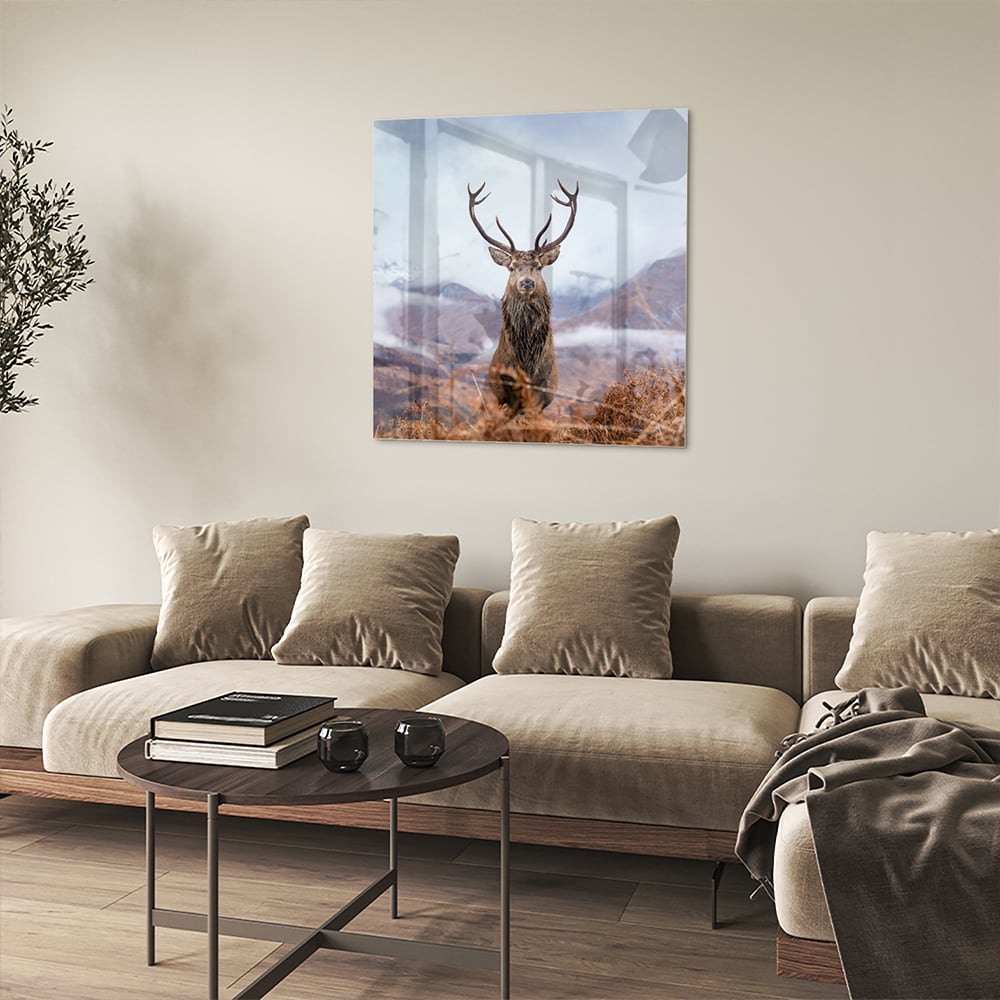 Glazen schilderij van een hert in een berglandschap met natuurlijke kleuren.