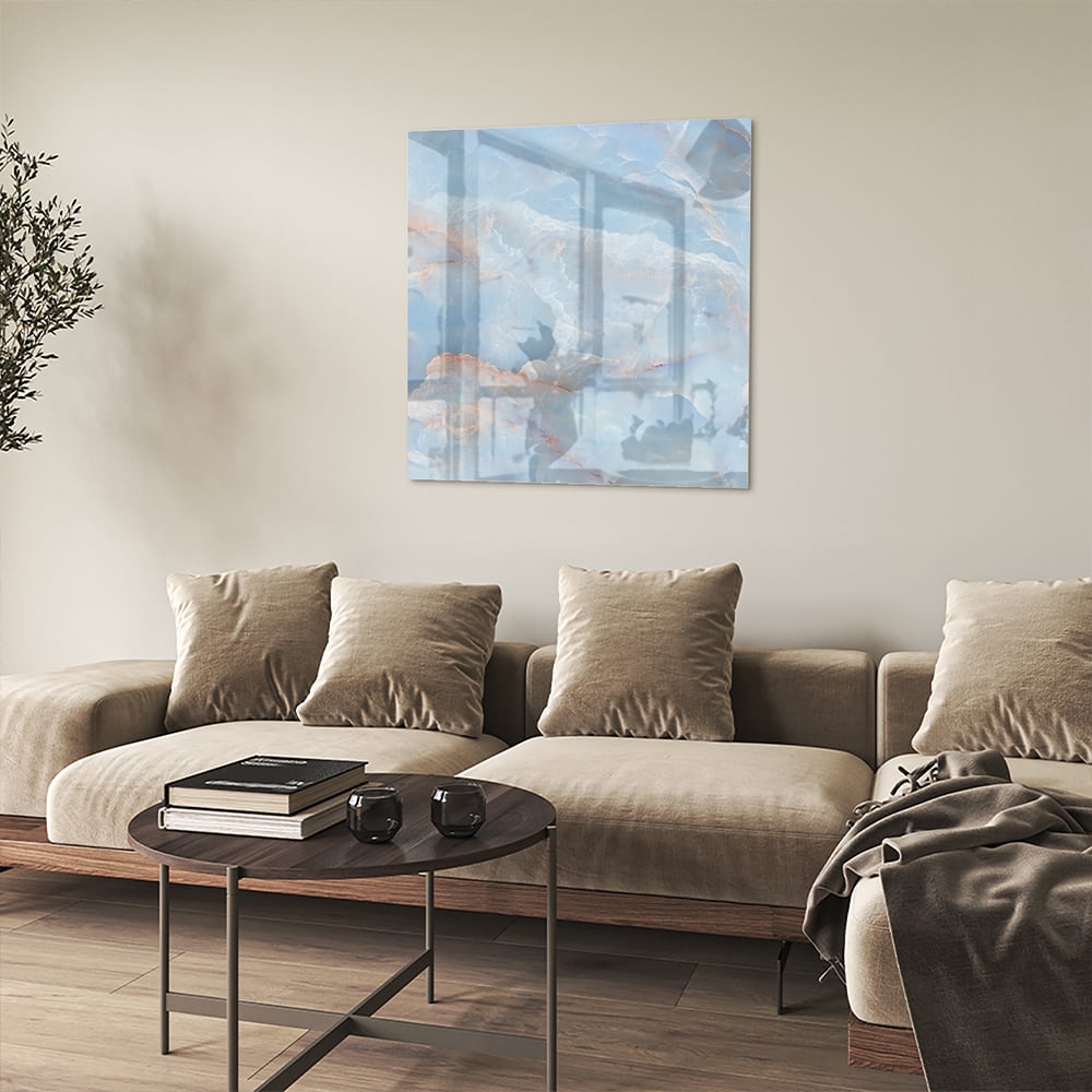 Abstract glazen schilderij in blauw en aardetinten aan de muur.