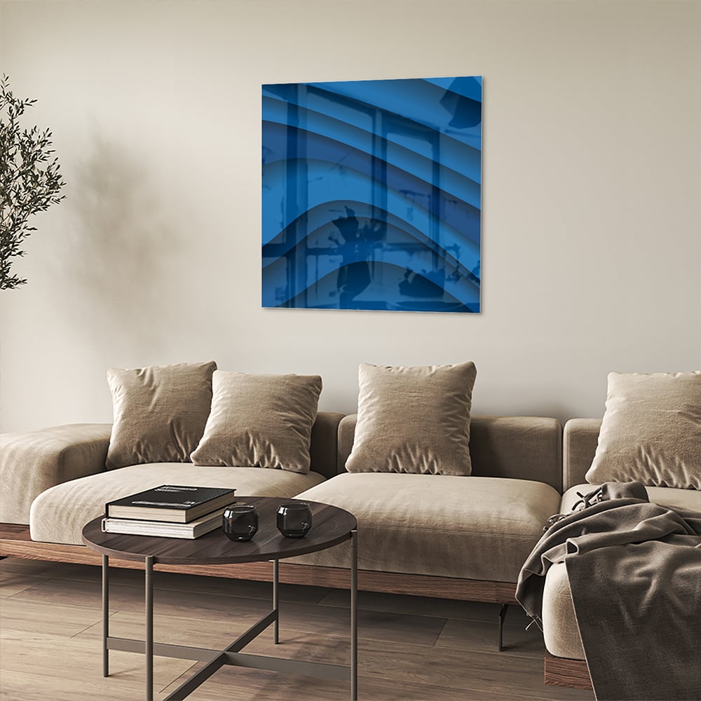 Modern glazen schilderij in abstracte blauwtinten op een muur.