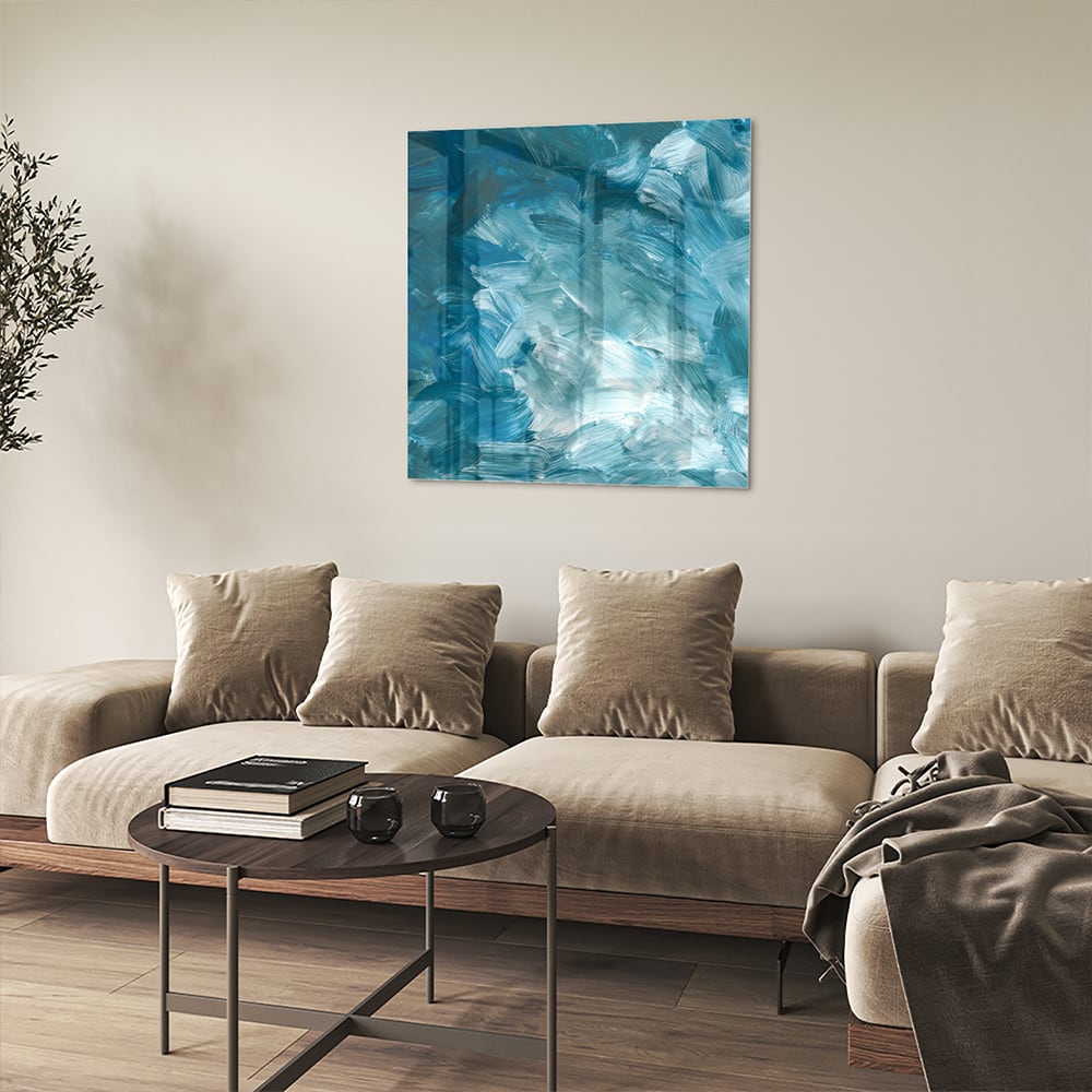 Abstract glazen schilderij met verschillende tinten blauw aan de muur.