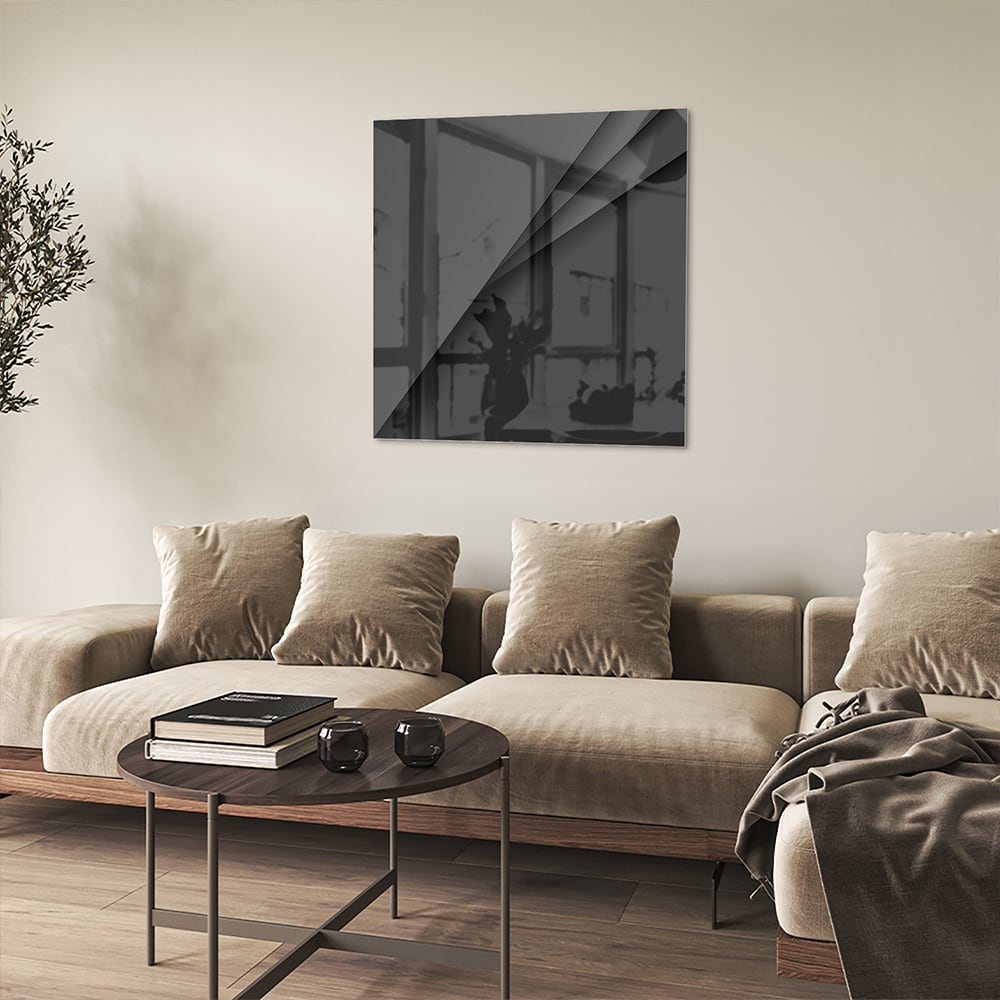 Zwart glazen schilderij aan een lichte muur in een modern interieur.