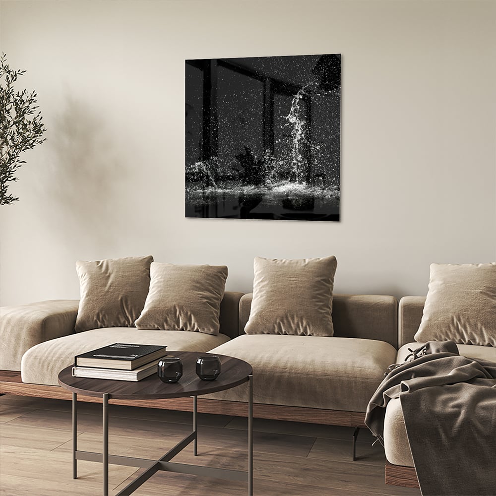 Zwart-wit glazen schilderij met een dynamisch spatwatereffect aan de muur.