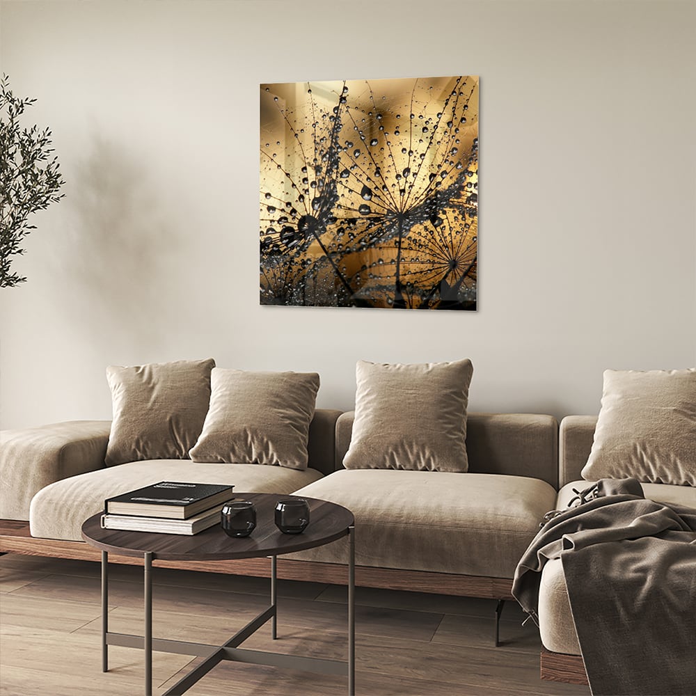 Glazen schilderij met gouden waterdruppels op een lichte muur.