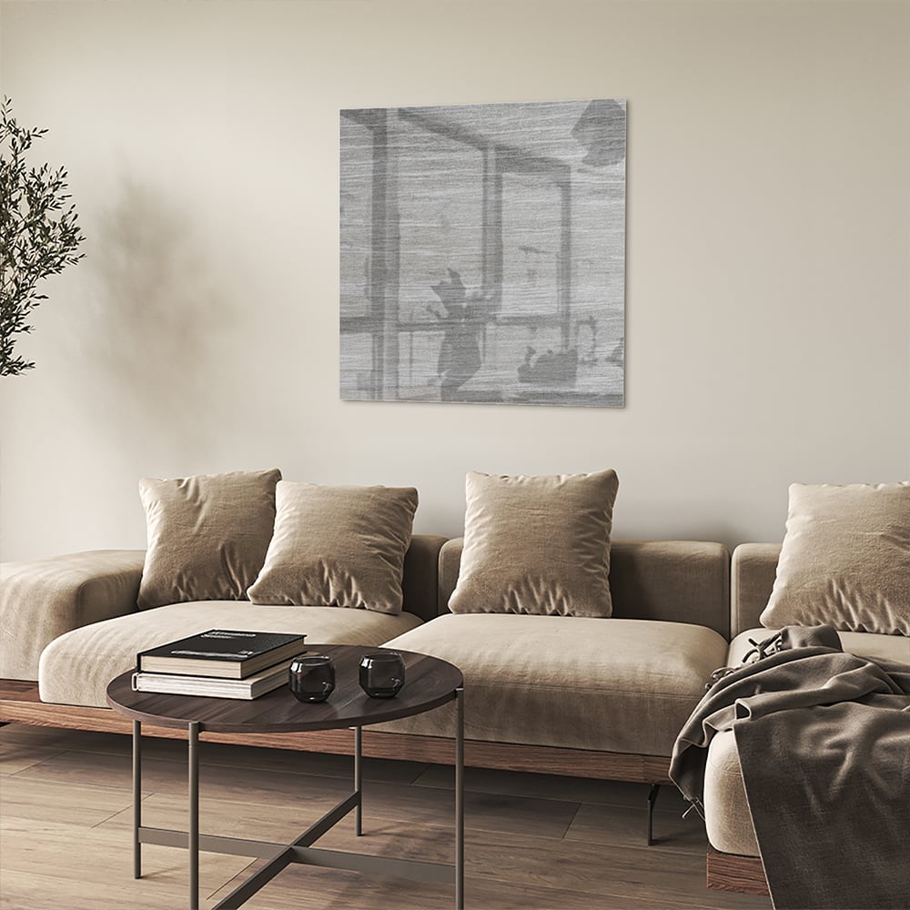 Minimalistisch glazen schilderij met grijstinten aan muur in moderne woonkamer.