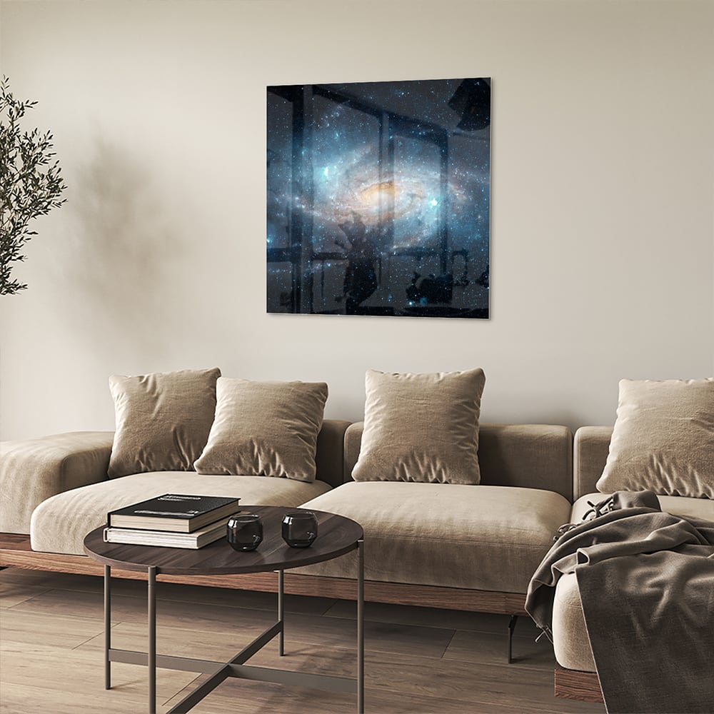 Glazen schilderij van een sterrenstelsel aan de muur in een moderne woonkamer.
