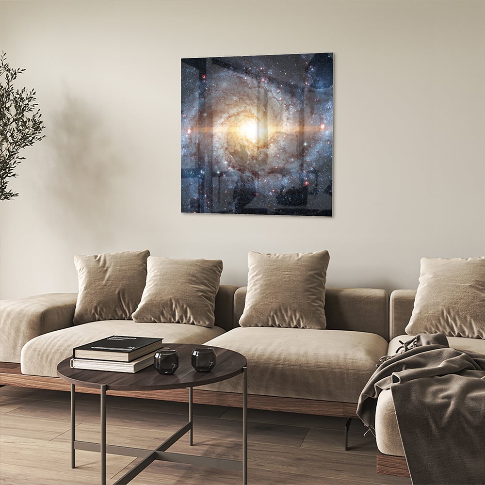 Glazen schilderij van een sterrenstelsel aan de muur in een lichte woonkamer.