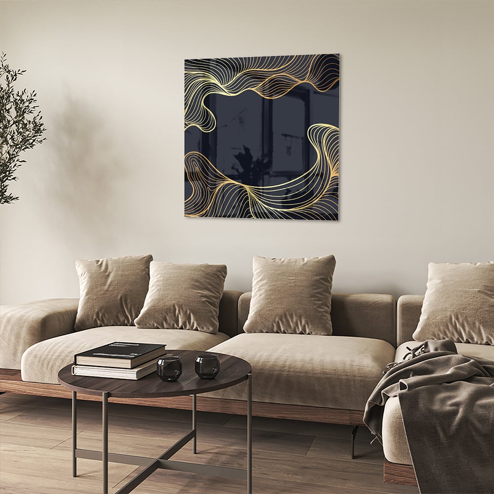 Glazen schilderij met gouden lijnen tegen een donkerblauwe achtergrond in een moderne woonkamer.