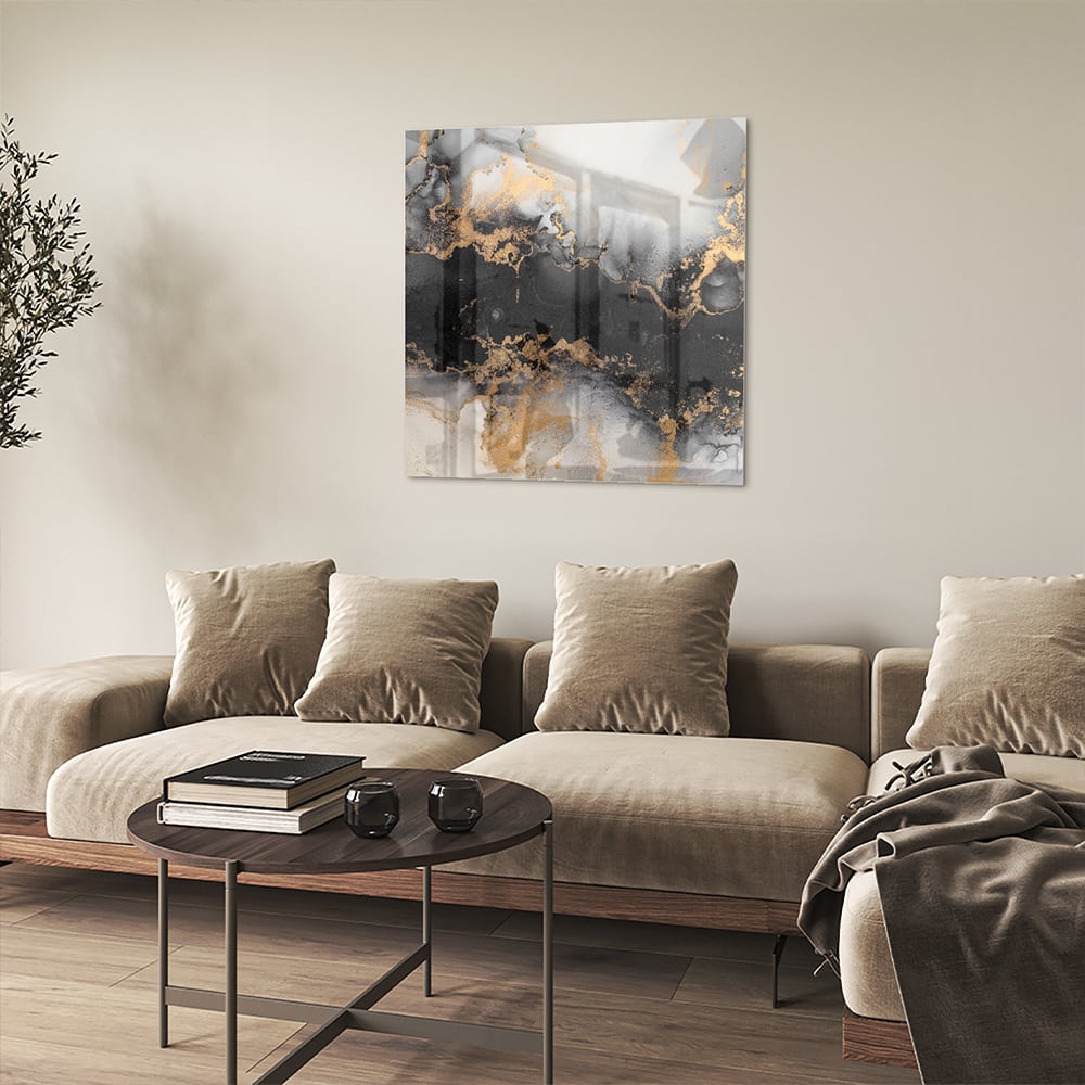 Glazen schilderij met zwarte en gouden abstracte patronen aan de muur boven een houten kast.