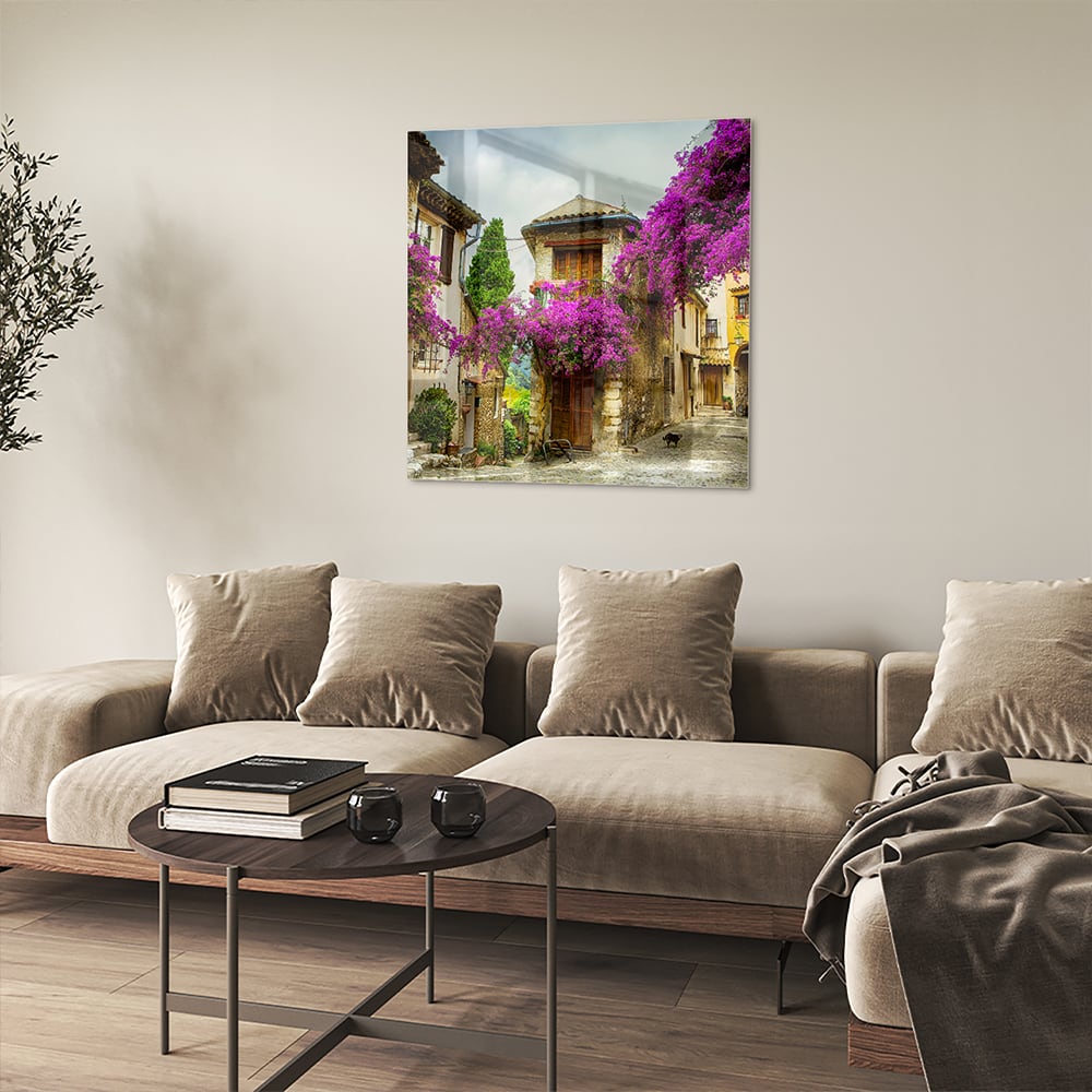 Glazen schilderij met een prachtig straatzicht en paarse bloesems in een helder interieur.