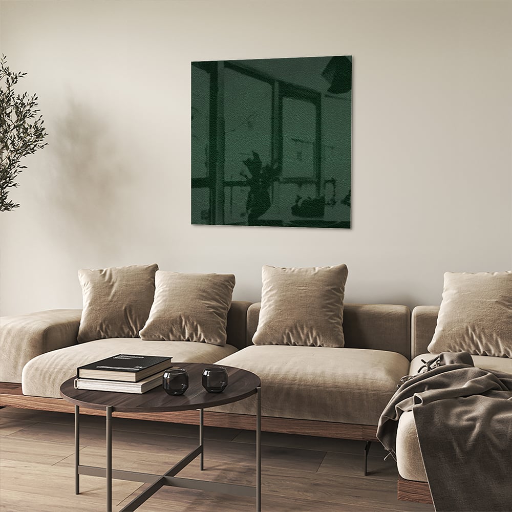 Een groen glazen schilderij aan de muur in een lichte woonkamer