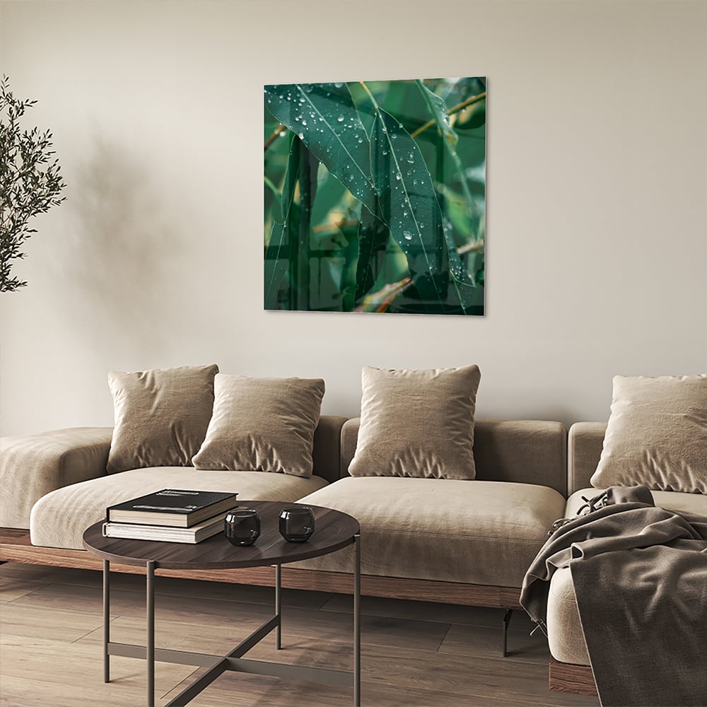Glas schilderij van groene bladeren met dauwdruppels in een interieur