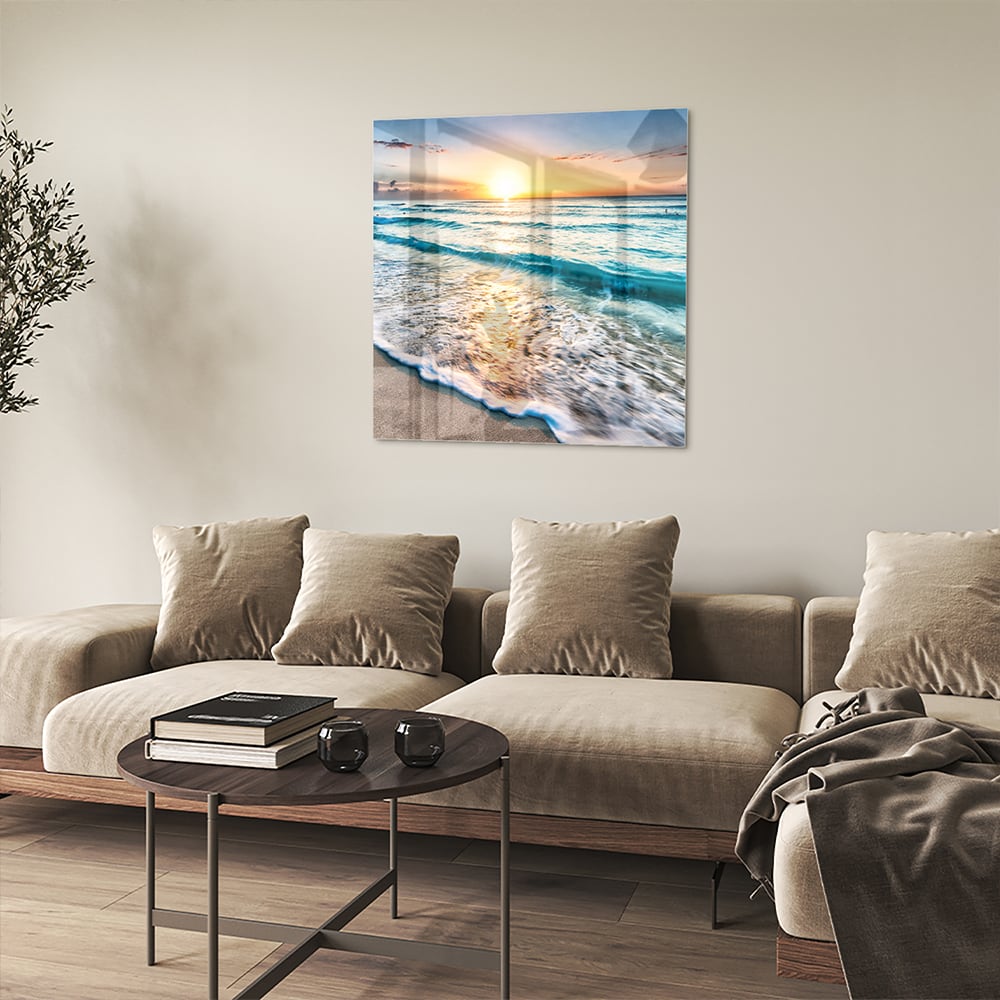 Glazen schilderij van een zonsondergang boven de zee, met kalme golven en zand.