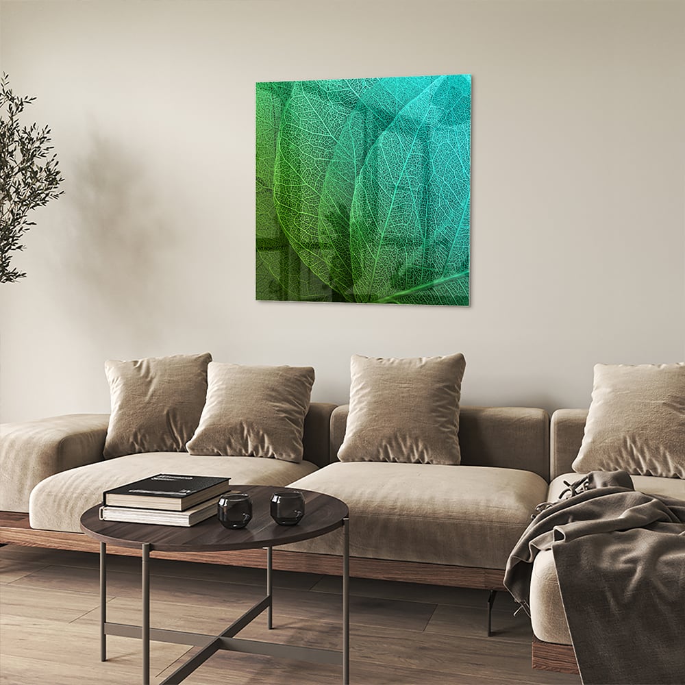 Glas schilderij met de structuur van groene bladeren aan een muur.
