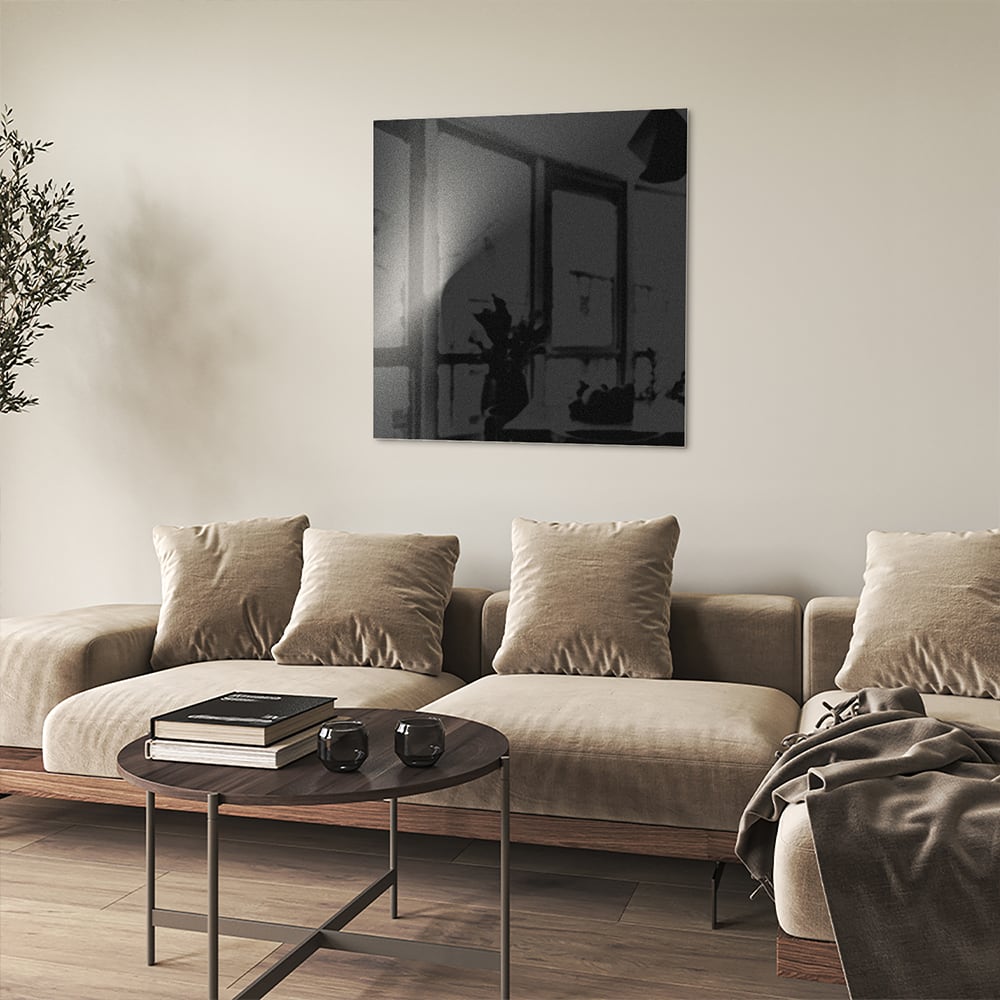 Moderne glazen schilderij op een witte muur in een stijlvolle woonkamer.