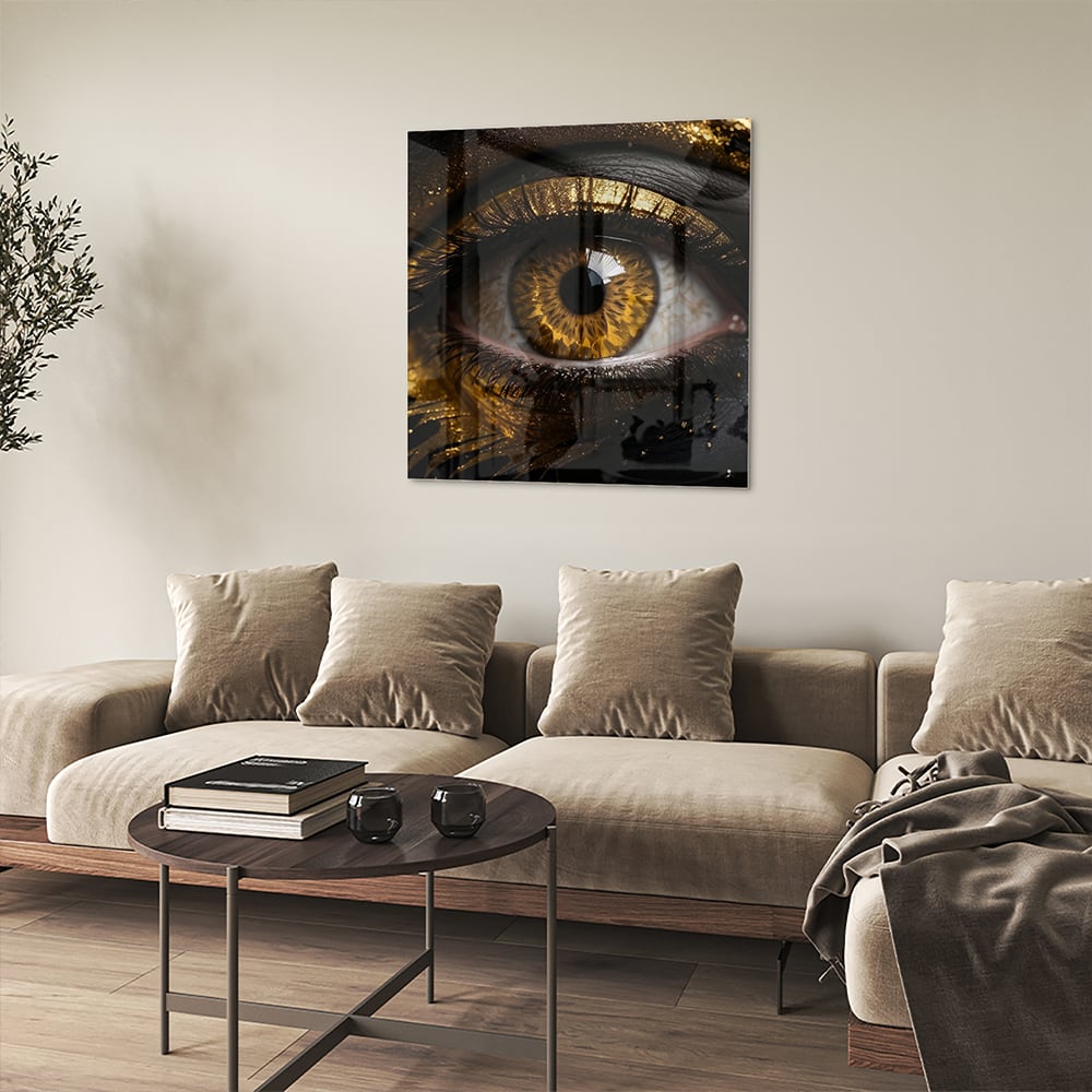 Glazen schilderij van een gouden oog op een zwarte achtergrond, hangt aan de muur.