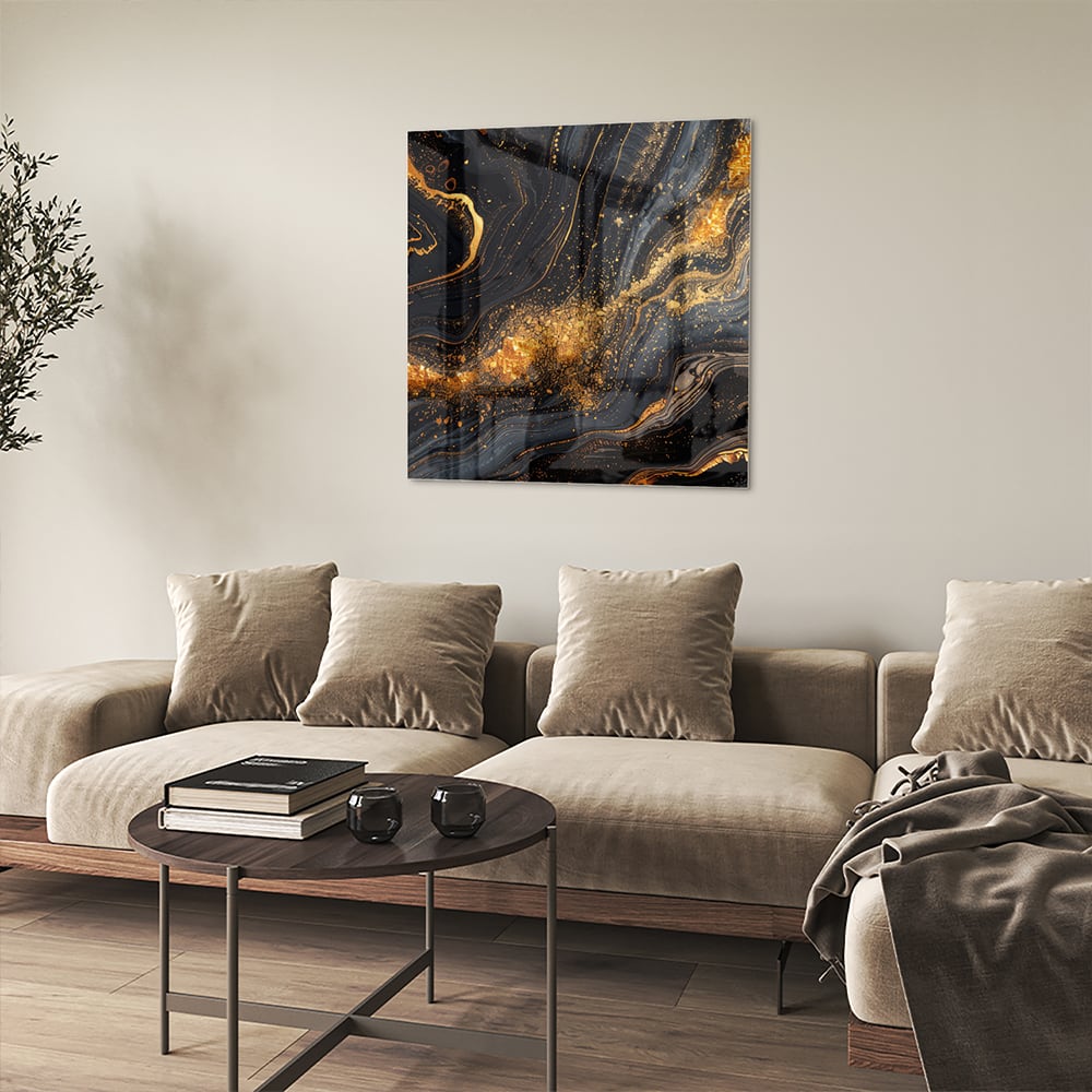 Glas schilderij met een zwart en gouden marmerdesign aan de muur in een moderne woonkamer
