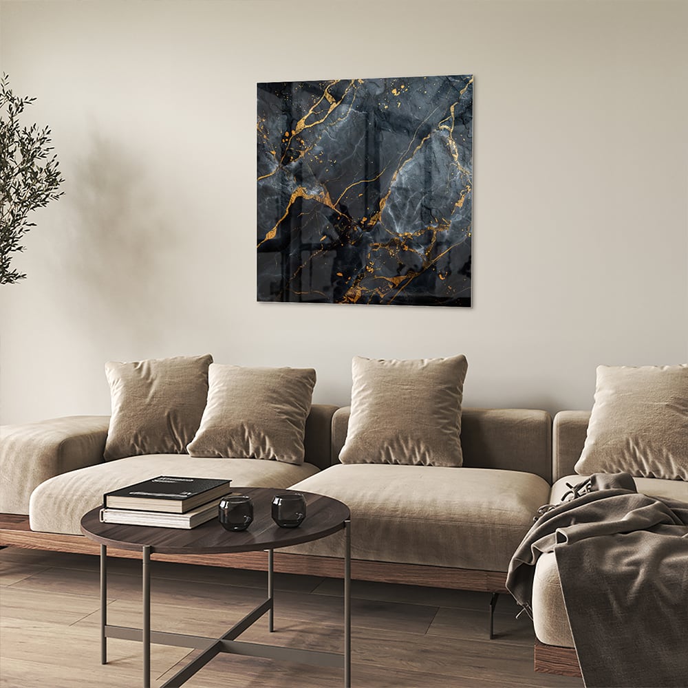 Glazen schilderij met marmerlook in zwart met gouden details aan de muur.