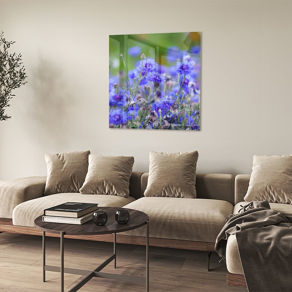 Glazen schilderij met paarse bloemen aan de muur in een lichte woonkamer.