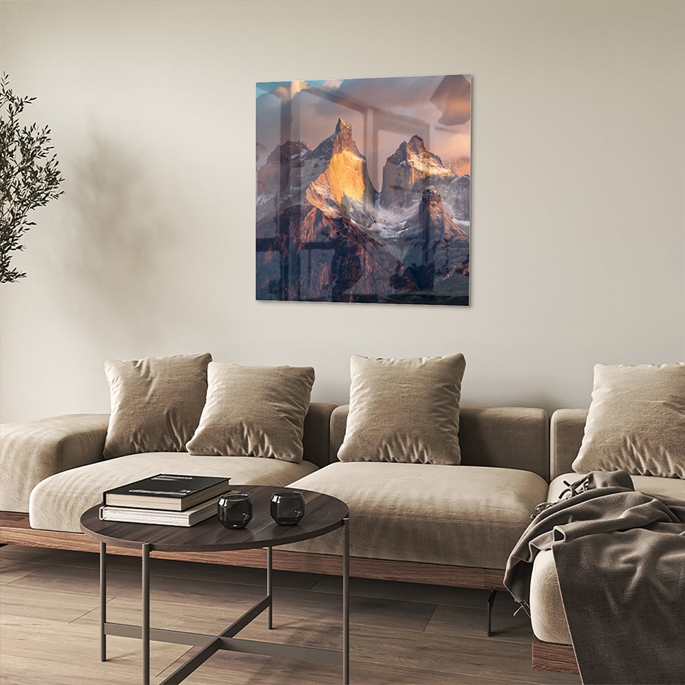 Glazen schilderij met berglandschap aan de muur in een moderne woonkamer