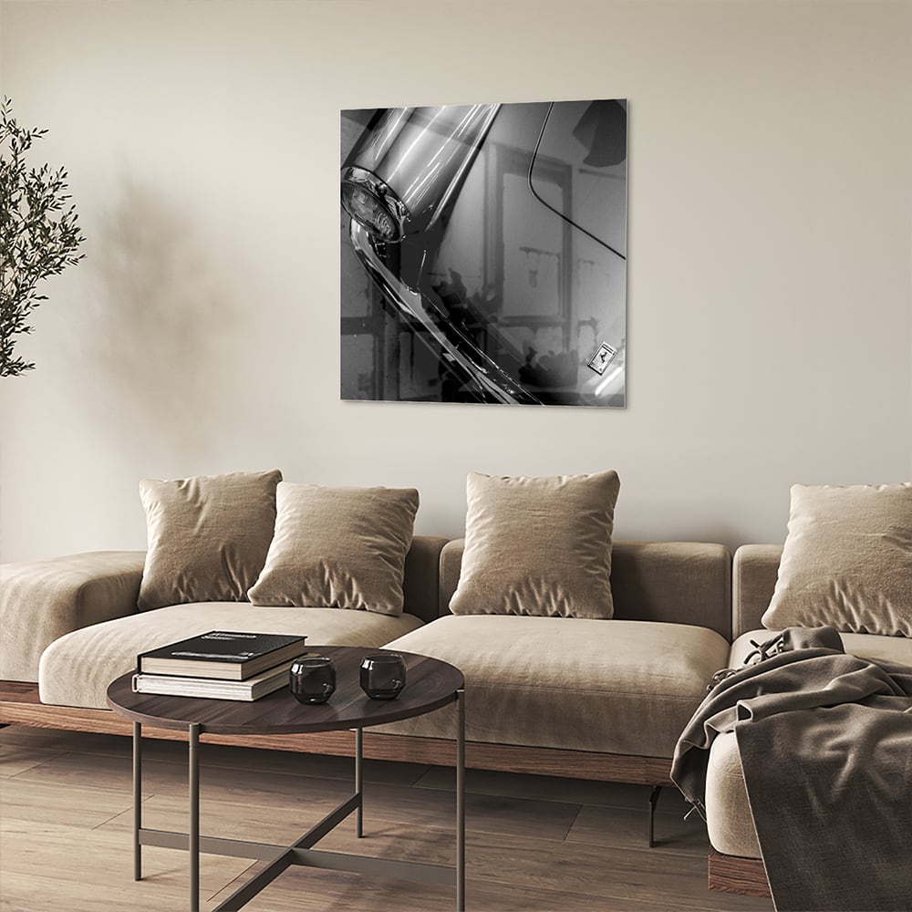 Glazen schilderij met abstracte vormen aan de muur in een stijlvolle kamer.