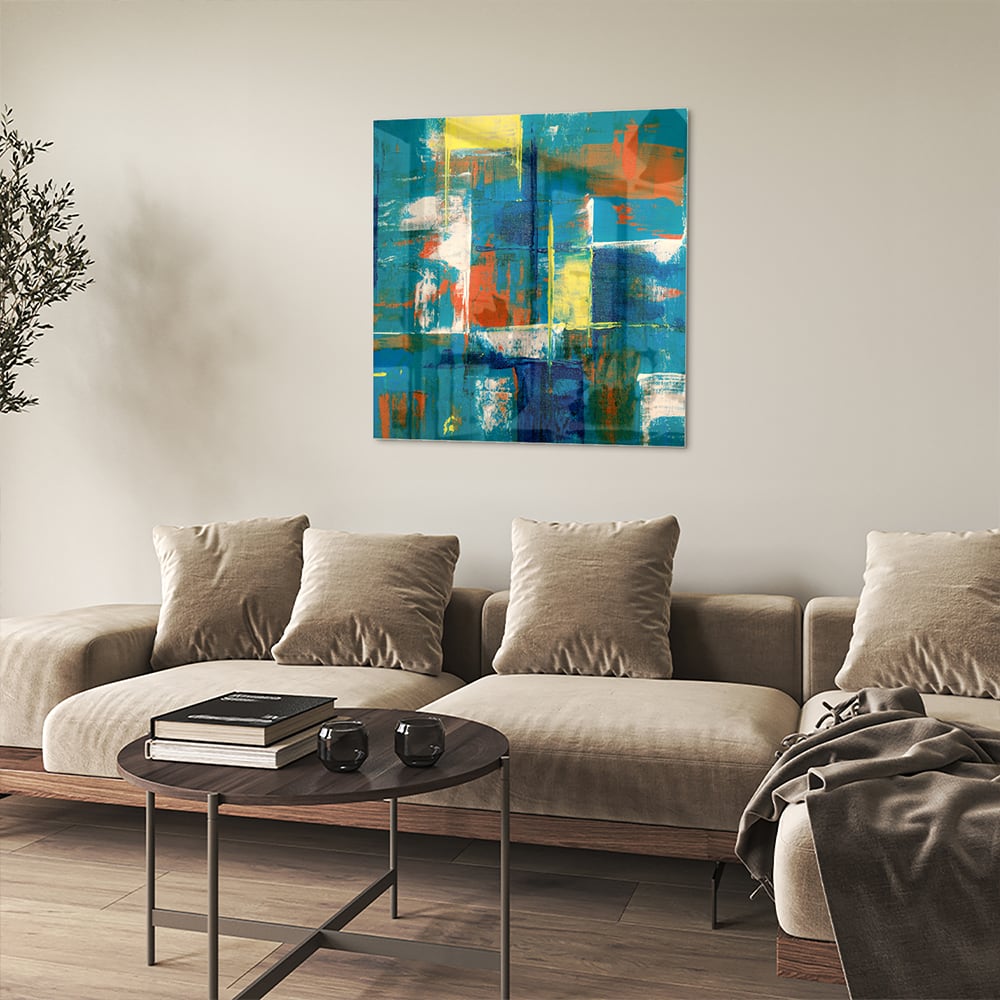 Kleurrijk abstract glazen schilderij in turquoise en oranje, genstalleerd in een moderne woonkamer.
